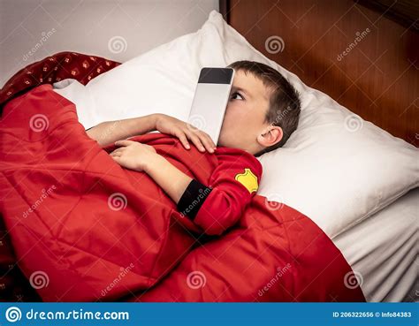 The Child in Bed Plays with the Mobile Phone before Sleeping Stock Photo - Image of falling ...