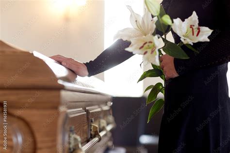 woman with lily flowers and coffin at funeral Stock Photo | Adobe Stock