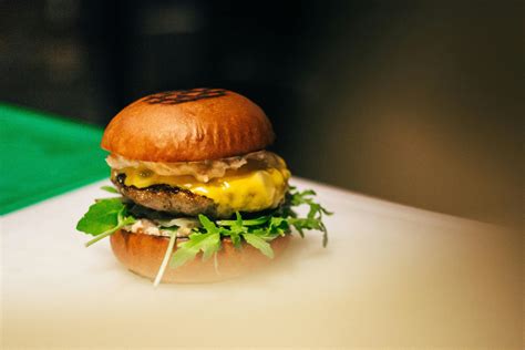 Person Holding Two Hamburgers · Free Stock Photo