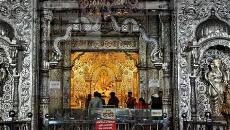 people standing in front of an ornately decorated building with gold and white decorations on it