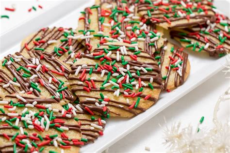 These colorful chocolate-drizzled Christmas cookies with holiday jimmies will delight kids of ...