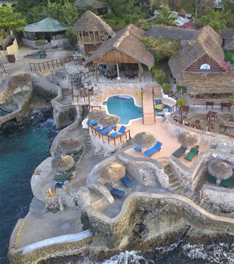 an aerial view of a resort with pools and cabanas on the rocks next to ...