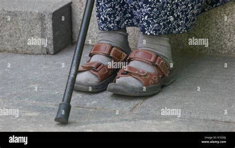 Old woman sitting with walking stick Stock Photo - Alamy