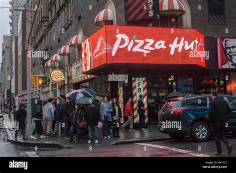 Advertising for Pizza Hut in a storefront in New York containing an assortment of fast food and ...