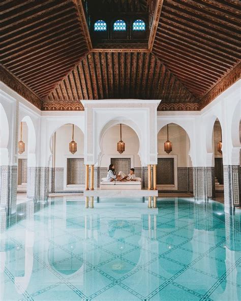 an indoor swimming pool with tiled floors and wooden ceilinging ...