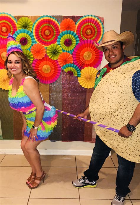 two people in costumes are holding a ribbon and posing for the camera while standing next to ...