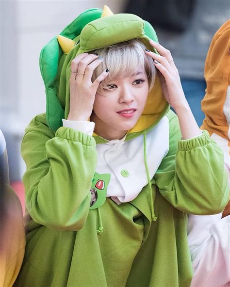 a woman in a green frog costume holding her hands to her head and ...
