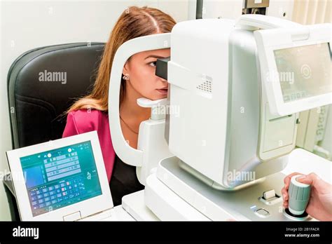 Beautiful woman having an eye lens exam with auto refractor keratometer ...