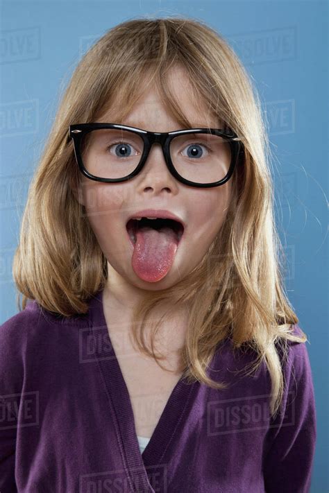 A young girl sticking out her tongue playfully, studio shot - Stock ...