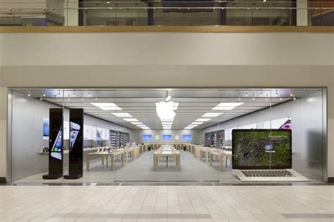 an apple store with two laptops on the floor and tables in front of them