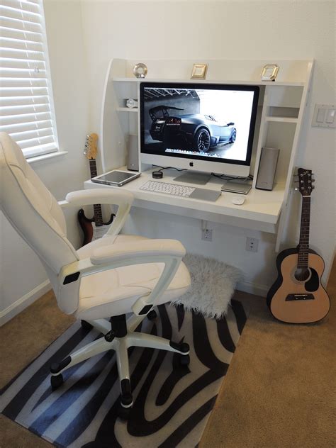 a computer desk with a guitar, keyboard and monitor