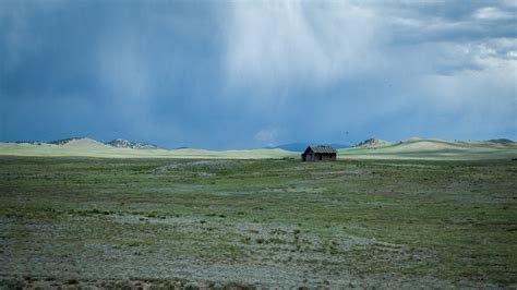 a bleak landscape with a wooden cabin on a desolate plain, lonely cabin 4k HD Wallpaper