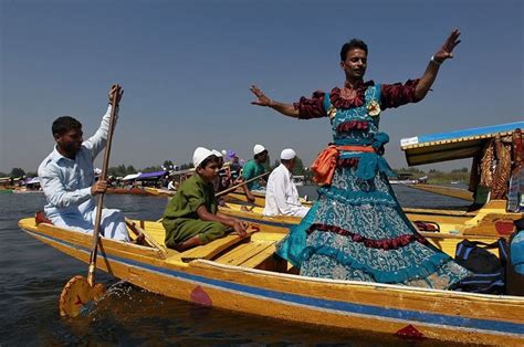 A Kashmiri folk dancer performs a dance on a floating Shikara (boat) during the Shikara Festival ...