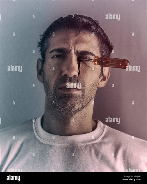 A man looking at the camera while the blood slips from his eye due to a screwdriver Stock Photo ...