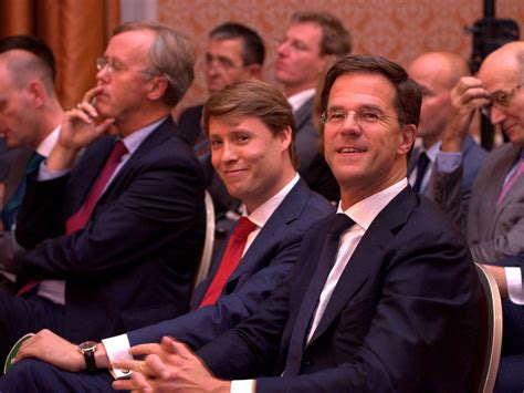 several men in suits and ties sitting next to each other at a meeting ...