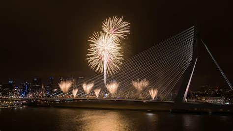 Premium Photo | Firework exploding over erasmus bridge at night