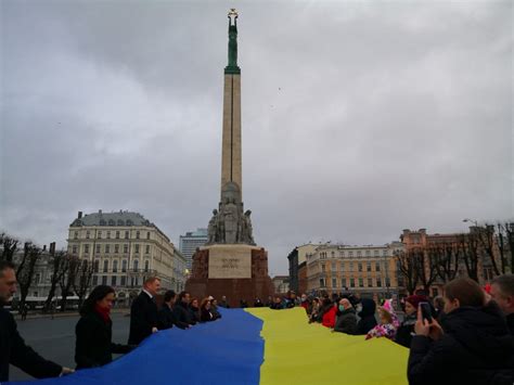 A large Ukrainian flag is solemnly displayed at the Freedom Monument ...