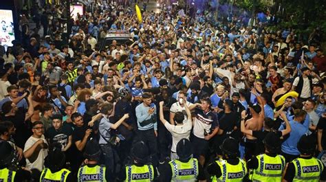 Ecstatic Manchester City fans mount bus stops and smash cars as cops swarm celebrations - Mirror ...