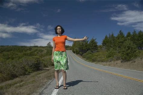 Young woman hitching a ride on lonely desert road — Stock Photo ...