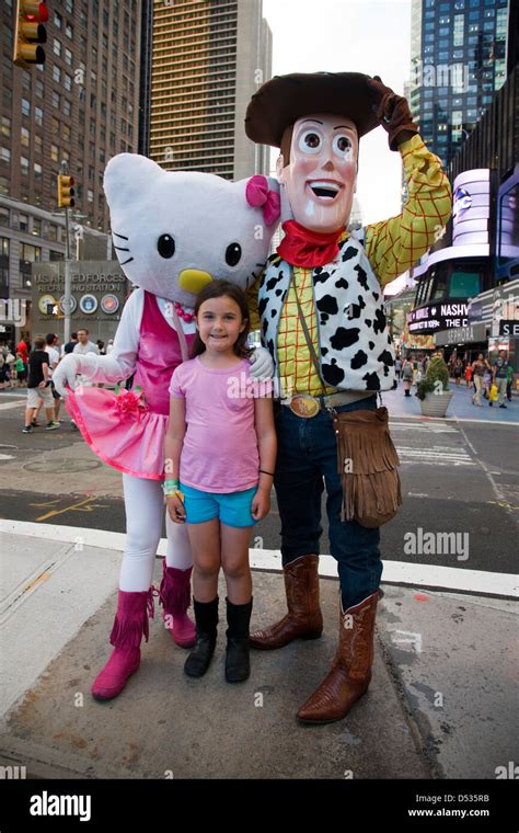 Hello Kitty and Toy Story Woody cartoon character costumes posing with children in Times Square ...