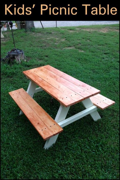 a picnic table with two benches in the grass