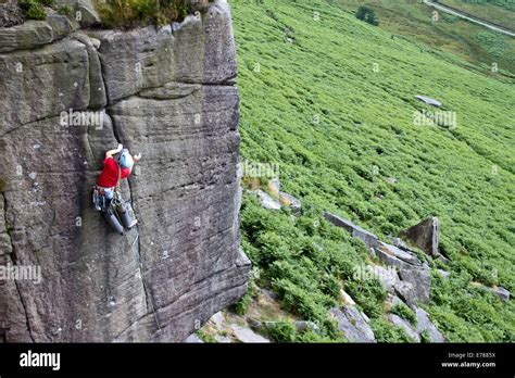 A man rock climbing at Stanage Edge nr Hathersage and Sheffield in the Peak District National ...