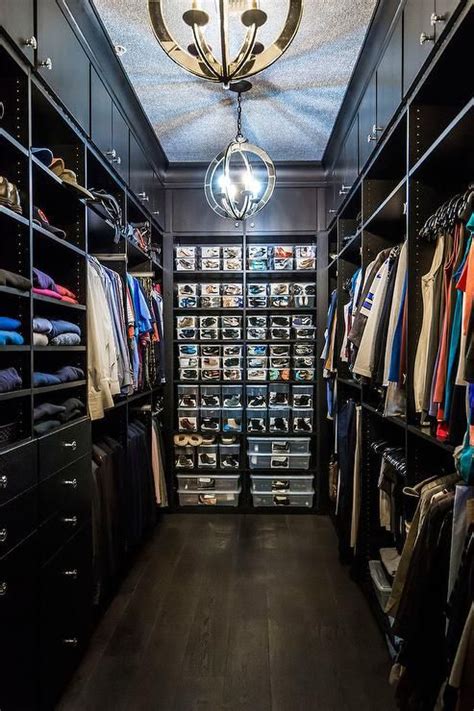 a walk in closet filled with lots of clothes and shoes next to a chandelier