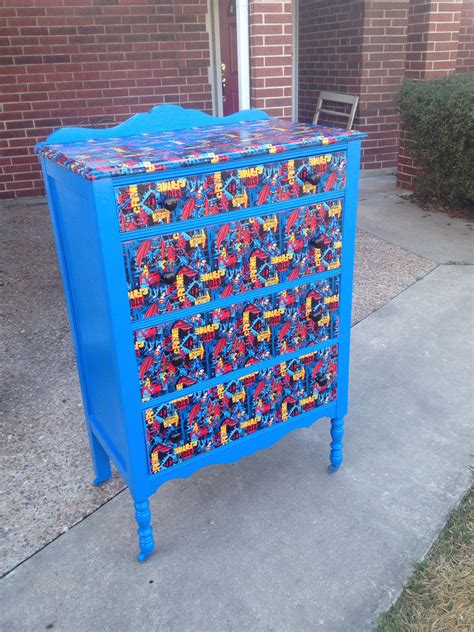 a blue painted dresser with legos on the top and bottom drawers is sitting in front of a brick ...