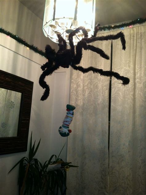 a spider is hanging from the ceiling in front of a curtain with lights on it