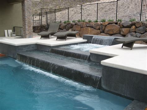 Tiered water feature design incorporates the features into joining the spa with the pool. This ...