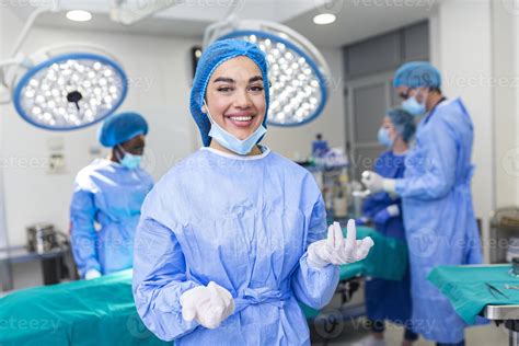 Portrait of happy woman surgeon standing in operating room, ready to ...