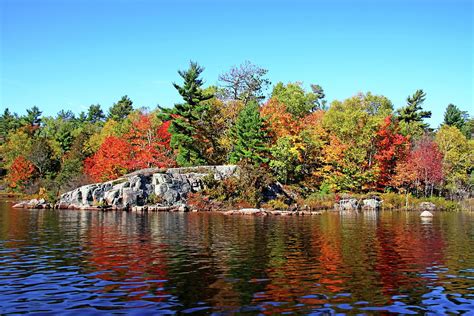 Fall Colors On Rocky River Shore Photograph by Debbie Oppermann - Fine ...