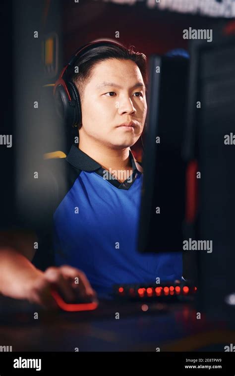 Playing online video games as professional. Vertical shot of concentrated asian guy, male cyber ...