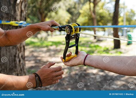 Two Men Setting Up Slacklining Equipment in City Park during Summer Day ...