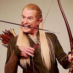 a man with long blonde hair holding an arrow and bow