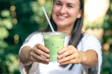 Premium Photo | Iced green tea with milk in woman hand