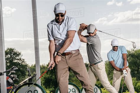 Group of friends playing golf together at golf course - Stock Photo ...