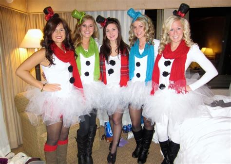 four women dressed up in costumes posing for a photo with snowmen on ...