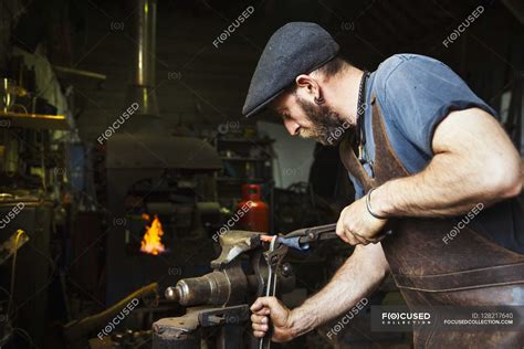 Blacksmith bends a cone of hot metal — leather, holding - Stock Photo ...