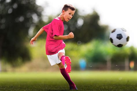 Boy kicking soccer ball stock photo. Image of action - 260608460