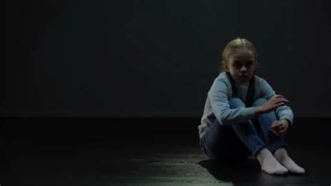 Scared little girl sitting alone in dark... | Stock Video | Pond5