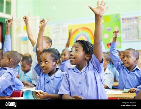 Students raising hands in class Stock Photo - Alamy