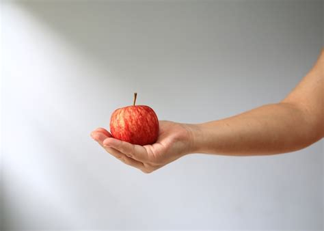 Premium Photo | Hand holding red apple.