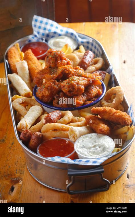 Platter with chicken goujons, crispy chicken wings, cocktail sausages ...