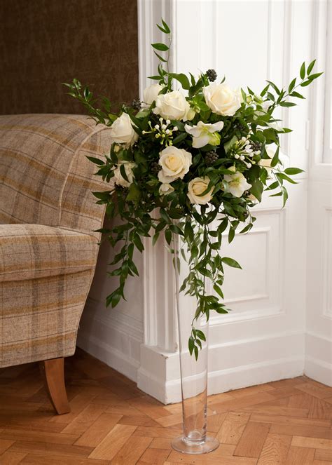 Tall glass vase with large and wild arrangement of ivory Roses and ...