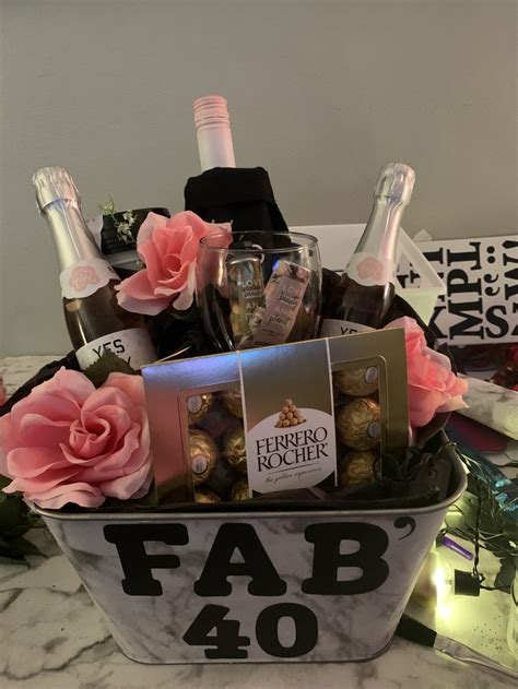 a basket filled with champagne and chocolates on top of a table next to ...