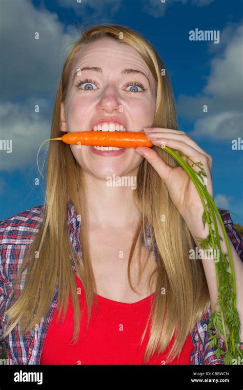 Woman biting carrot outdoors Stock Photo - Alamy