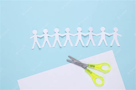 Premium Photo | Paper cut chain of people with scissors on blue background