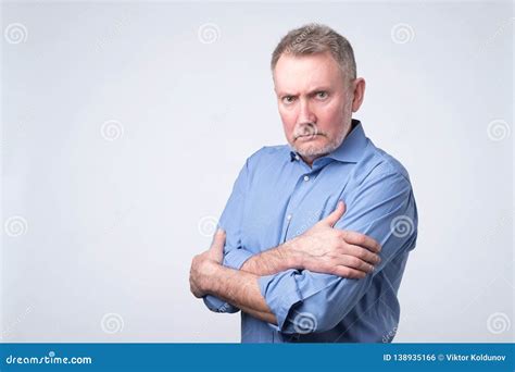 Serious Senior Man with Folded Arms and a Deadpan Expression Posing on ...