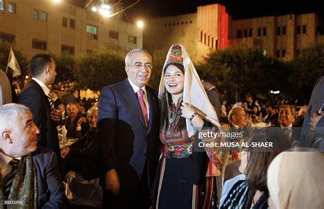 Palestinian prime minister Salam Fayyad stands with a symbolic bride ...